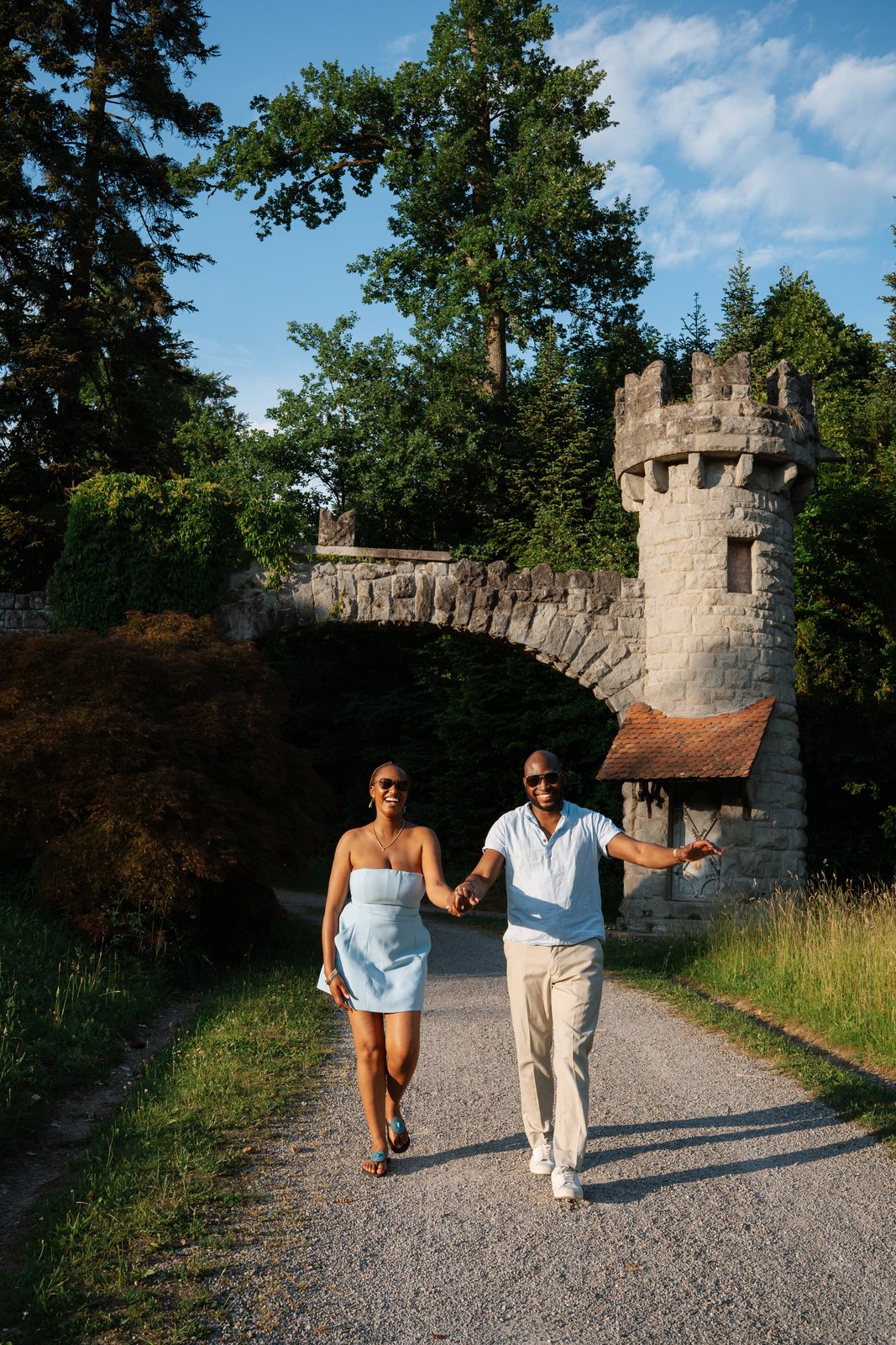 The couple walking hand in hand through the castle gate